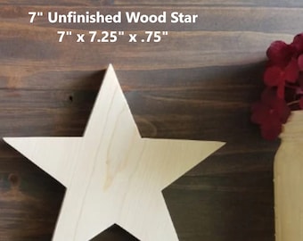 May include: Unfinished wood star, 7 inches in diameter, with a 7 inch by 7.25 inch by .75 inch measurement. The star is light brown and is sitting on a dark brown wooden surface.