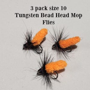 May include: Three size 10 Tungsten Bead Head Mop Flies. Each fly has a black body, black hackle, and an orange mop head. The flies are designed for fishing.