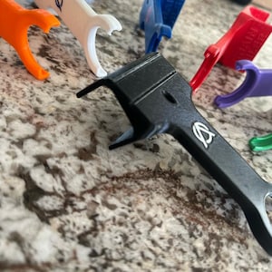 Pu&ograve; includere: Assortimento di pezzi in plastica stampati in 3D di vari colori con un logo. I pezzi sono di varie forme e dimensioni, tra cui un pezzo nero con un logo.