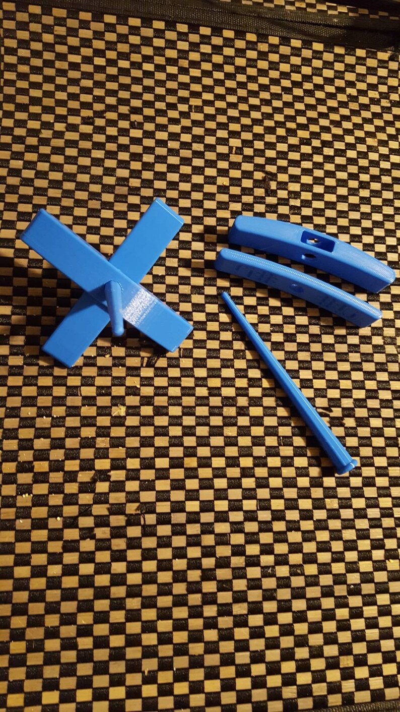 Peut inclure: Un rouet bleu avec une broche et trois pi&egrave;ces suppl&eacute;mentaires. Le rouet est en plastique et a une base en forme de croix.