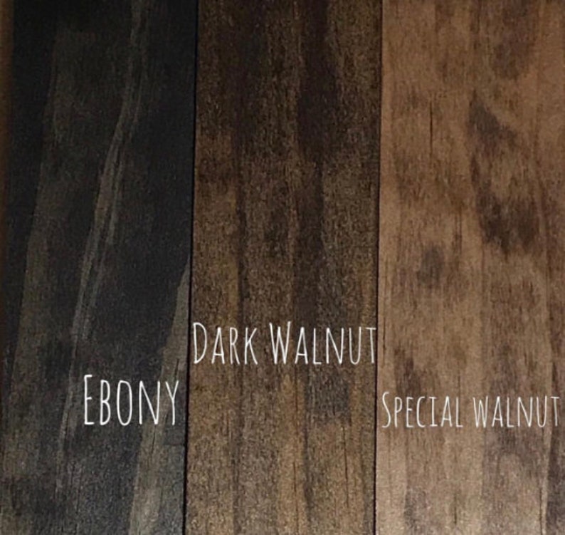 May include: A close-up of three wood stain samples: Ebony, Dark Walnut, and Special Walnut. The names of the stains are written in white script. The wood grain is visible in each sample, showcasing the different tones of brown.
