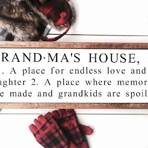 May include: A rectangular wooden sign with the text "GRANDMA'S HOUSE, n." in black. The sign's definition includes "A place for endless love and laughter" and "A place where memories are made and grandkids are spoiled."