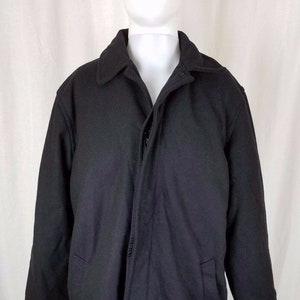 May include: A black long-sleeved coat with a zipper closure and two pockets. The coat is made of a thick, warm fabric.