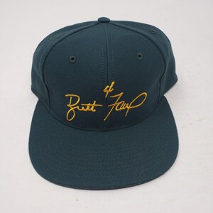May include: A dark green baseball cap with a gold embroidered signature that reads "#4 Brett Favre".
