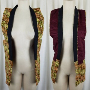 May include: A black and burgundy reversible vest with a geometric pattern in yellow and orange. The vest has a collar and is open in the front.