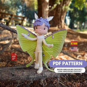 Puede incluir: Una muñeca de ganchillo hecha a mano con un diseño de hada. La muñeca tiene cabello morado claro, plumas blancas y alas verde claro. La muñeca está de pie sobre una rama de árbol. La imagen incluye el texto "PDF PATTERN" y "MOON AMIGURUMI CROCHET / LUNA AMIGURUMI CROCHET".