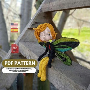 May include: A crocheted amigurumi fairy doll with yellow hair and wings. The doll is made with black, green, and yellow yarn. The image includes the text "PDF PATTERN" and a Spanish flag.