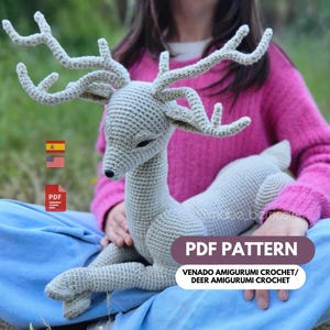 May include: A crocheted deer amigurumi in light gray, with detailed antlers and a black nose. The deer is lying down, with the text "PDF PATTERN" and "VENADO AMIGURUMI CROCHET/ DEER AMIGURUMI CROCHET" in a banner.