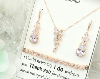 May include: A gift box with a rose gold necklace, earrings, and bracelet set with clear cubic zirconia stones. The box includes a card that reads "Bridesmaid 1 Could never say i do without you Thank you for standing with me on this special day."