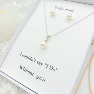 May include: A white gift box with a pearl necklace and earrings set. The box has the text "Bridesmaid" and "I couldn't say "I Do" Without you" printed on it.