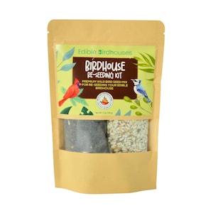 May include: A package of birdseed mix for edible birdhouses. The package has a clear window showing two compartments of seed. The label reads "Edible Birdhouses" and "Birdhouse Re-Seeding Kit". Illustrations of a red cardinal and a blue jay are on the label.