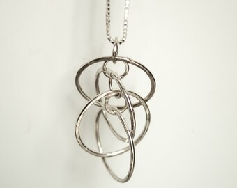 Pendant in sterling silver with hammered dancing hoops on a box chain