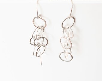 Earrings, drop, in sterling silver with a cascade of small hammered silver rings