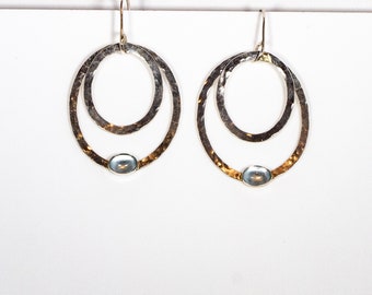 Earrings, drop, in sterling silver with two hammered hoops and oval blue topaz cabochons