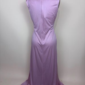 May include: A sleeveless, floor-length lavender dress. The dress has a fitted bodice and a flowing skirt that flares out at the bottom. A zip runs down the back of the dress. The dress is displayed on a mannequin.