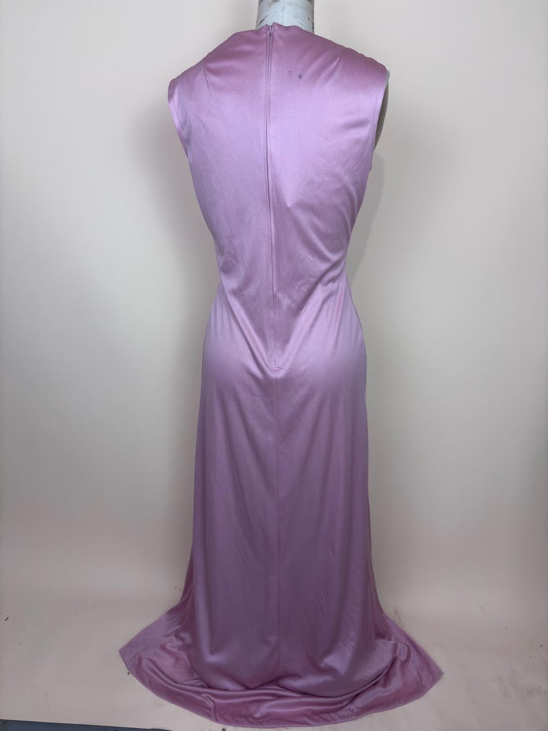 May include: A sleeveless, floor-length lavender dress. The dress has a fitted bodice and a flowing skirt that flares out at the bottom. A zip runs down the back of the dress. The dress is displayed on a mannequin.