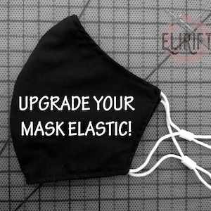 Puede incluir: Máscara facial negra con elásticos blancos y el texto "UPGRADE YOUR MASK ELASTIC!" impreso en la parte delantera.