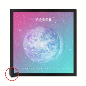 Op de afbeelding: Een ingelijste print met een blauwe en groene afbeelding van de aarde tegen een roze en blauwe sterrenhemel. De tekst "EARTH" staat bovenaan de afbeelding en "PLANET IN OUR SOLAR SYSTEM" staat onderaan.