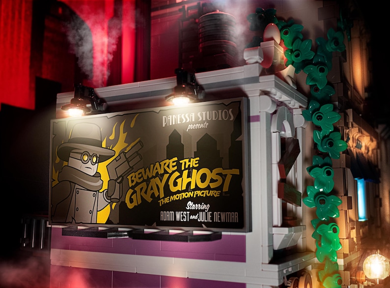K&ouml;nnte beinhalten: Ein Vintage-Filmplakat, das f&uuml;r "Beware the Gray Ghost" mit Adam West und Julie Newmar wirbt. Das Plakat wird von zwei Scheinwerfern beleuchtet und zeigt ein Cartoon-Bild eines Mannes in einem grauen Mantel und einer Schutzbrille, der eine Waffe h&auml;lt.
