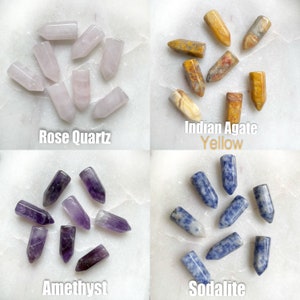 Four sets of polished gemstone points. The top left set is rose quartz points in light pink. The top right set is Indian agate points in yellow, brown, and white. The bottom left set is amethyst points in purple. The bottom right set is sodalite points in blue.