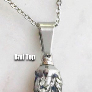 May include: Silver chain necklace with a silver bail top. The bail top is a simple, flat, rectangular shape with rounded edges. The chain is a delicate, curb chain.