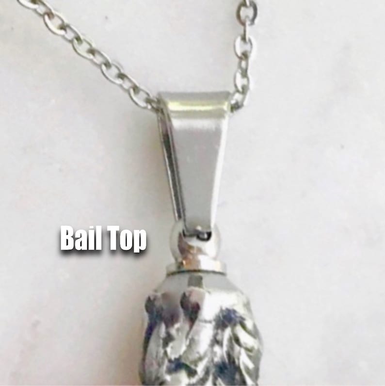 May include: Silver chain necklace with a silver bail top. The bail top is a simple, flat, rectangular shape with rounded edges. The chain is a delicate, curb chain.