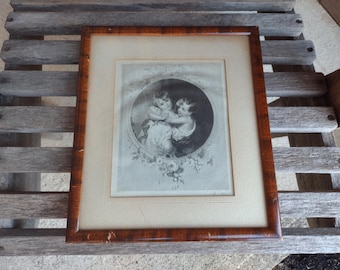 May include: A framed black and white print of two children, a girl and a boy, in a vintage style. The children are dressed in simple clothing and are holding hands. The print is surrounded by a decorative border of flowers and leaves.