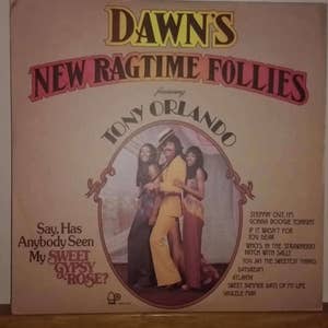 May include: A vintage vinyl record cover featuring a group of three people, two women and one man, in a colorful setting. The cover is titled "Dawn's New Ragtime Follies featuring Tony Orlando". The text "Say, Has Anybody Seen My Sweet Gypsy Rose?" is also featured on the cover.