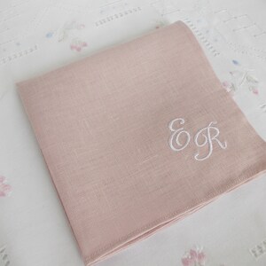 May include: A pale pink linen handkerchief with the embroidered initials "E & R" in white thread.
