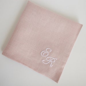 May include: A pale pink linen handkerchief with white embroidered initials "E & R".