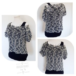 Op de afbeelding: Een zwart-wit gecrochete crop top met een losse pasvorm en korte mouwen. De top heeft een licht off-shoulder ontwerp. De tekst "ANNAH HAAKT Crop Top" is zichtbaar in de afbeelding.