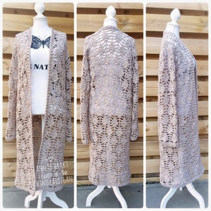 Op de afbeelding: Een beige gehaakte cardigan met een kantpatroon. De cardigan is open aan de voorkant en heeft lange mouwen. De tekst "Leaves in the Wind Cardigan" is zichtbaar onderaan de afbeelding.