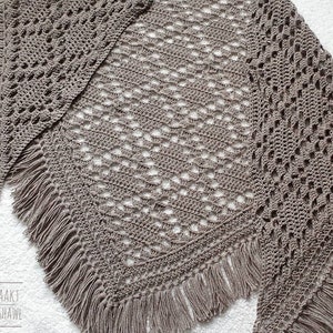 May include: A brown crocheted shawl with a diamond pattern and fringe. The shawl is laid out on a white surface. The text "ANNAH HAAKT DIAMOND SHAWL" is visible in the bottom left corner of the image.