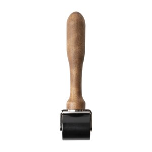 May include: A wooden handled roller with a black rubber roller. The roller is used for applying pressure to surfaces.