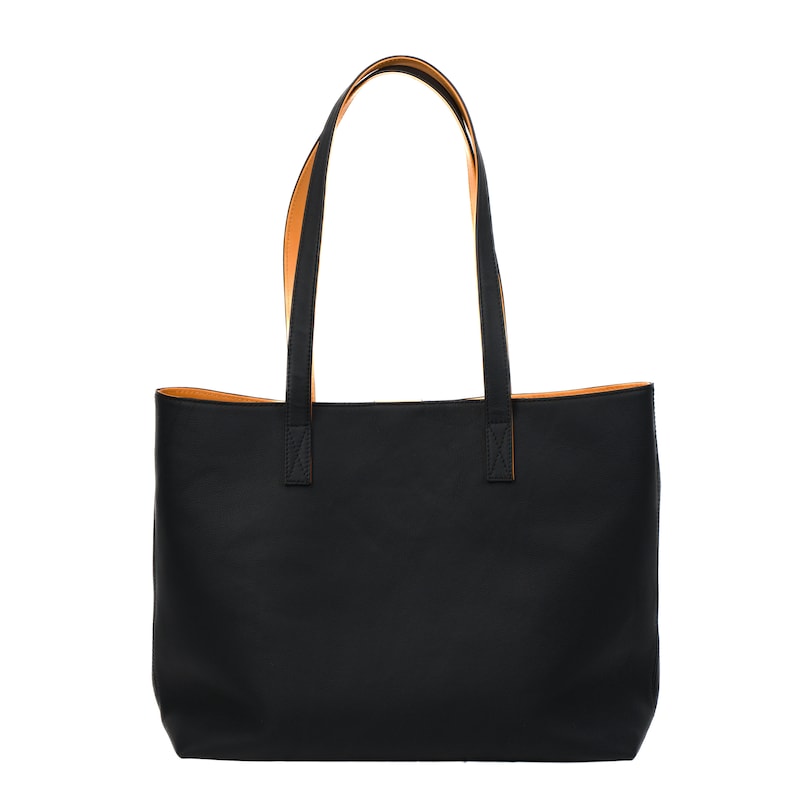Handcrafted pebbled black leather tote bag for women, made in Spain. Spacious, fits 17" laptop, features cotton lining, calfskin straps, and a detachable pouch. Elegant, durable, perfect for work or as a gift.