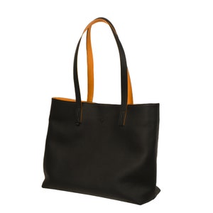 Handcrafted pebbled black leather tote bag for women, made in Spain. Spacious, fits 17" laptop, features cotton lining, calfskin straps, and a detachable pouch. Elegant, durable, perfect for work or as a gift.