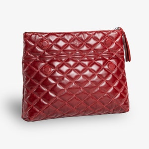 Op de afbeelding: Een gestikte rode leren clutch met een ritssluiting en een kwast.