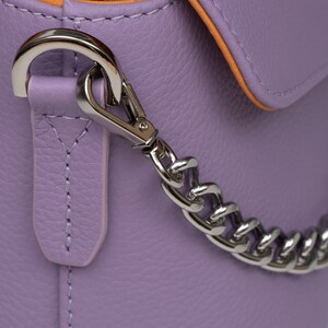 PEGAI Helen Lilac Pebbled Calfskin Leather Handbag featuring a sleek crossbody design, adjustable metal and leather strap, nickel-plated hardware, and a secure magnetic closure. Perfect for a luxurious and stylish look.