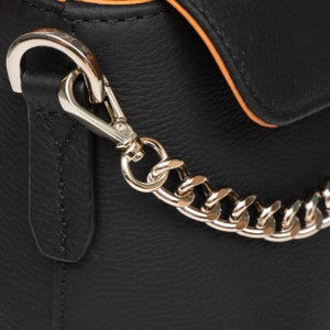 PEGAI Helen Black Pebbled Calfskin Leather Handbag featuring a sleek crossbody design, adjustable metal and leather strap, gold-plated hardware, and a secure magnetic closure. Perfect for a luxurious and stylish look.