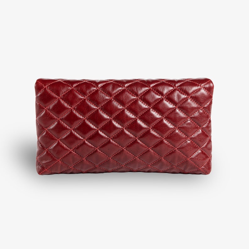 Op de afbeelding: Een bordeauxrode quilted leren clutch.