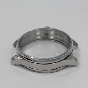 May include: A silver-toned watch case with a clear glass face. The case has a circular design with curved lugs for the watch band. The watch case is made of metal and has a polished finish.