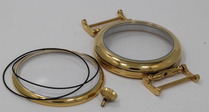 May include: Gold-toned watch case back with a clear glass insert and a black rubber gasket. The case back is separated from the glass insert and gasket. A small gold-toned screw is also included.