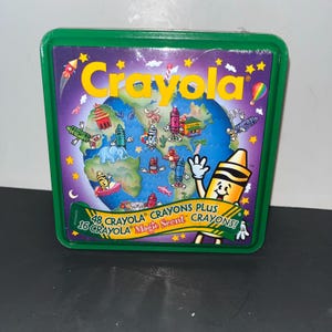 Pode incluir: Um recipiente quadrado de plástico verde com um gráfico da Crayola mostrando um globo rodeado por personagens de giz de cera, estrelas e um foguete. O texto diz 48 Crayola Crayons Plus 16 Crayola Magic Scent Crayons numa faixa amarela e verde.