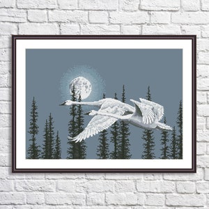 May include: Two white swans fly in front of a full moon and a dark forest silhouette. The moon is a light blue color with a white center.