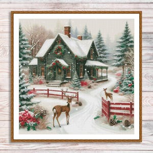 May include: A snowy winter scene with a green house decorated with Christmas lights and garlands. Two deer stand in the snow near a red wooden fence.