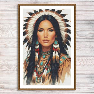 Puede incluir: Retrato enmarcado de una mujer con largo cabello negro, adornada con un tocado de plumas y joyas turquesas. El retrato presenta una temática nativa americana, con abalorios detallados y detalles de plumas. La obra de arte está sobre un fondo de madera clara.