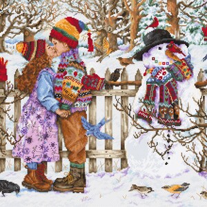 May include: A cross-stitch winter scene depicts a boy and girl kissing near a snowman. The boy wears a colorful hat and sweater, while the girl wears a purple dress. A snowman with a black hat and scarf stands nearby. Birds perch on a wooden fence.