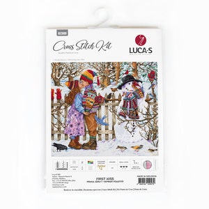 May include: A cross-stitch kit titled "First Kiss" featuring a winter scene with a couple kissing and a snowman. The kit includes the Luca-S logo, color and skill level indicators, and the text "Quality Premium Line."