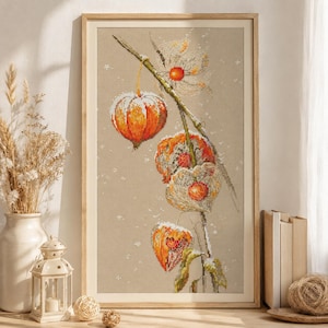 Peut inclure: Une broderie au point de croix encadrée représentant une branche de physalis orange sur un fond en tissu beige clair. Le motif présente des détails brodés des enveloppes papyracées et des baies orange vif, dans un cadre en bois simple.