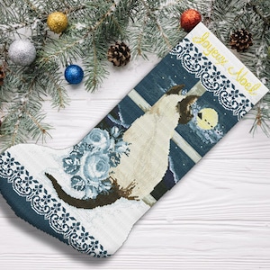 Puede incluir: Una media navideña azul y blanca con un diseño de gato blanco y el texto "Joyeux Noel".